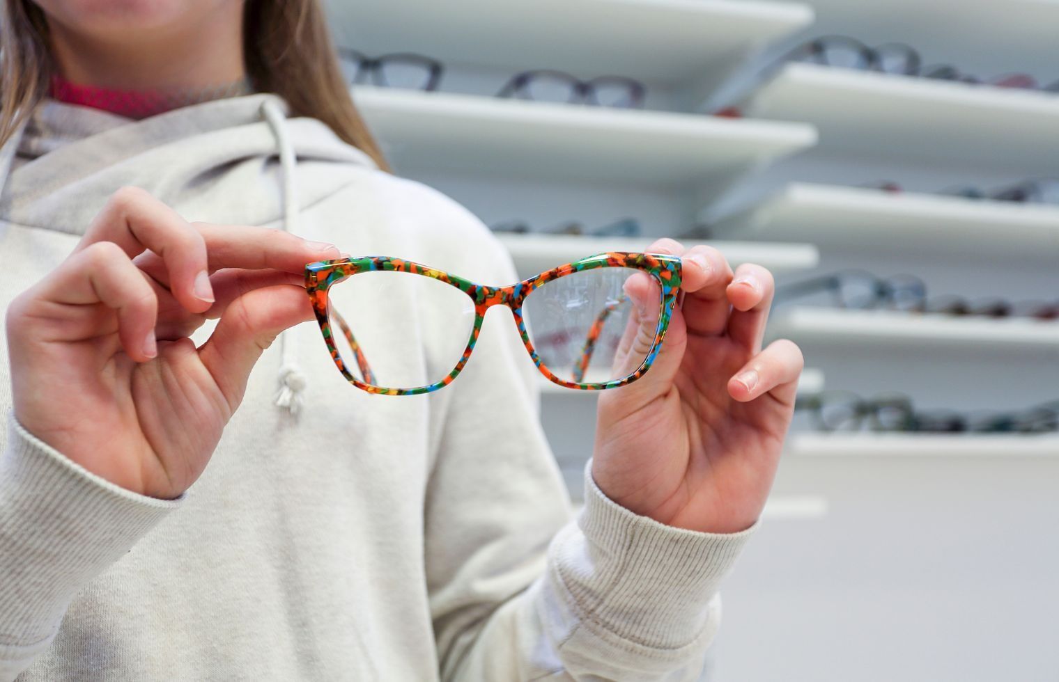 Adolescente essayant des lunettes chez l'opticien
